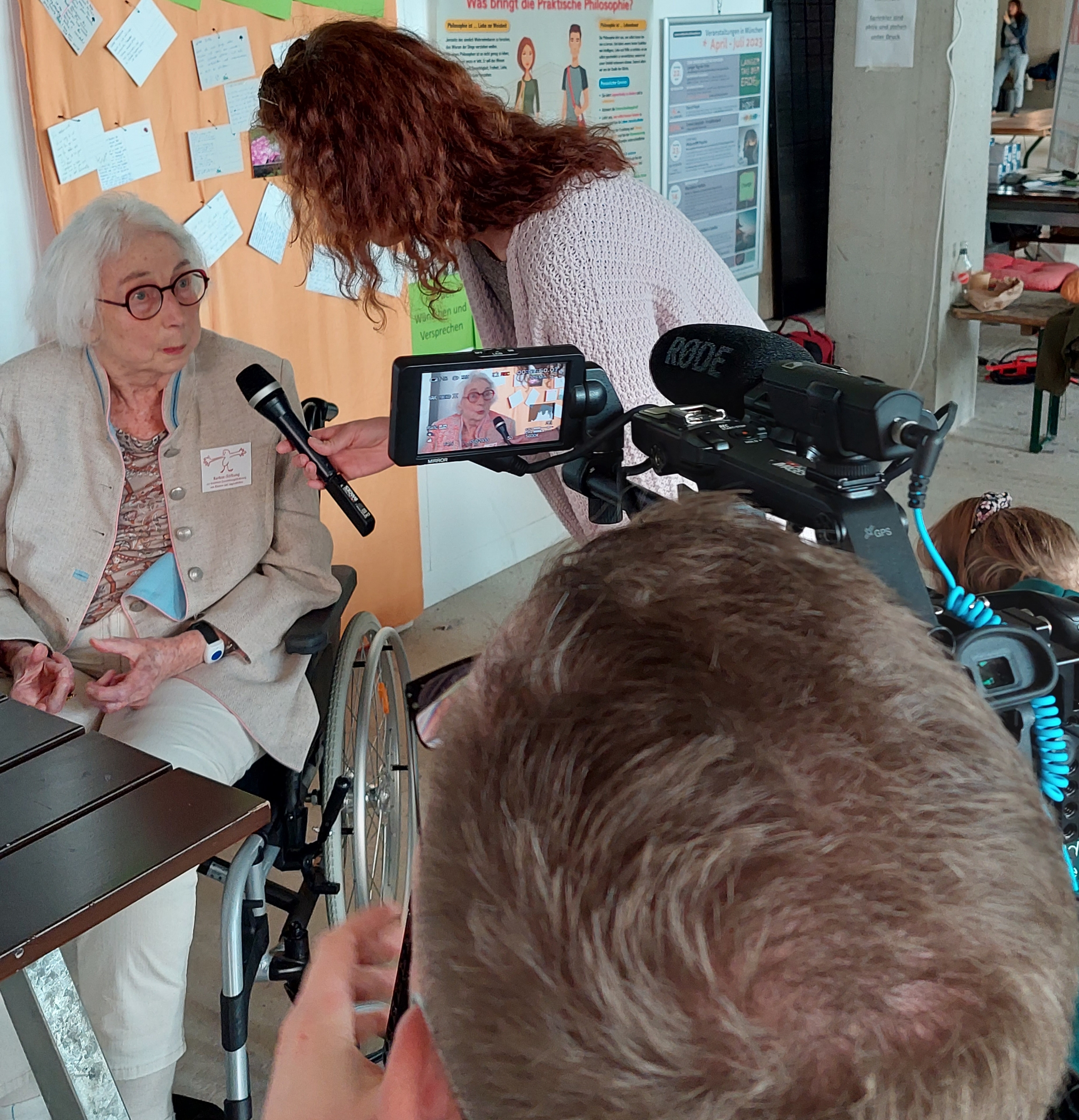 Redakteurin mit Mikrofon und Kameramann interviewen Stifterin Barbara Osterwald